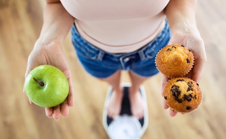 apple and muffins in womans hand